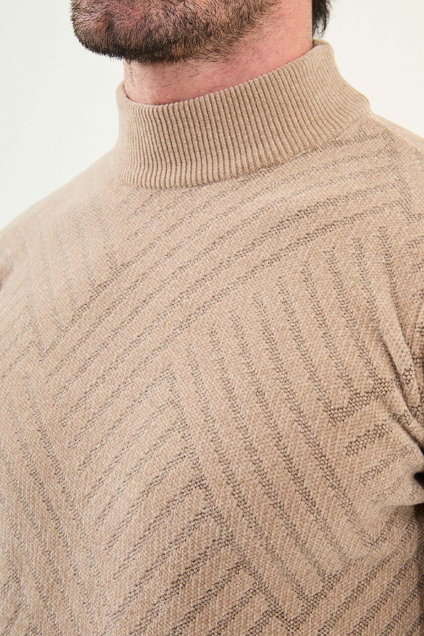 A man wearing a slim fit beige turtleneck knitwear sweater with geometric patterns, paired with dark trousers for a refined fall-winter look.