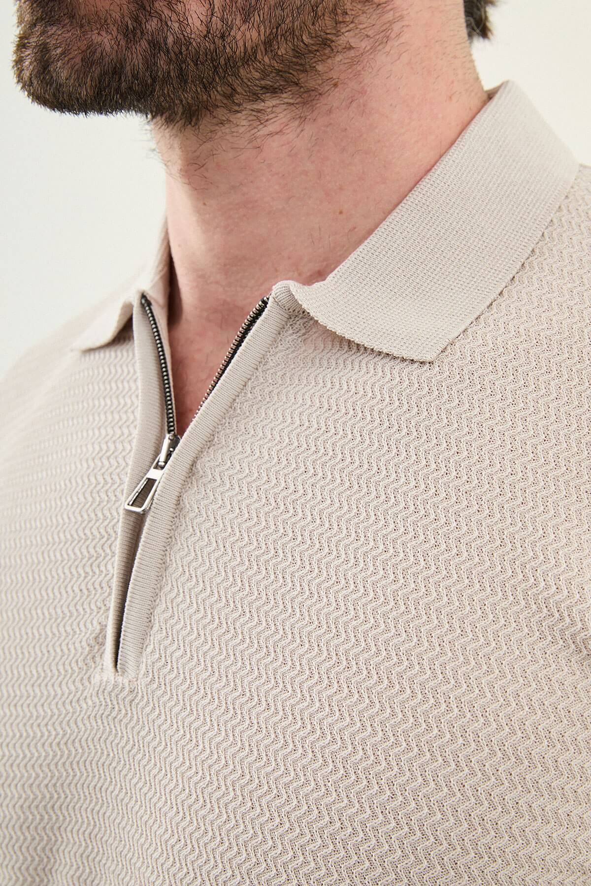 Man wearing a beige slim-fit quarter-zip polo T-shirt, short sleeves, styled for summer casual wear, standing against a neutral background.