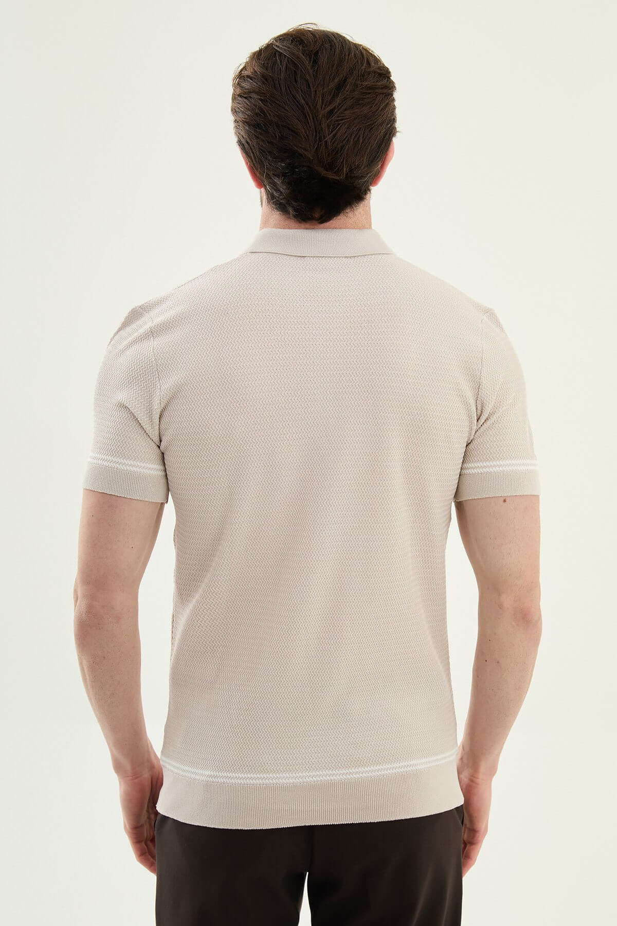 Man wearing a beige slim-fit quarter-zip polo T-shirt, short sleeves, styled for summer casual wear, standing against a neutral background.