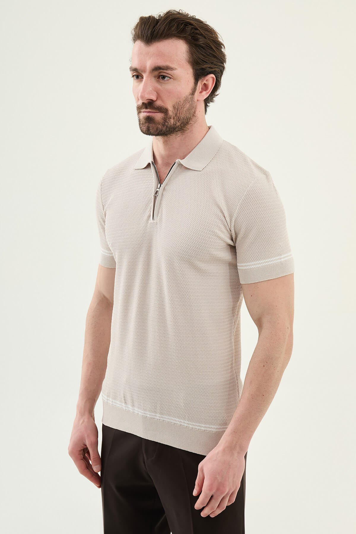 Man wearing a beige slim-fit quarter-zip polo T-shirt, short sleeves, styled for summer casual wear, standing against a neutral background.