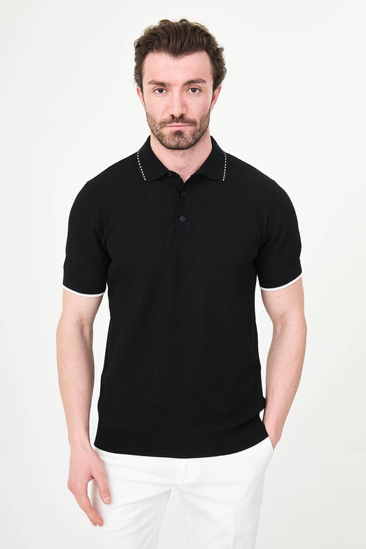 Man wearing black slim-fit quarter-zip polo t-shirt with white stripe accents, styled with white trousers.