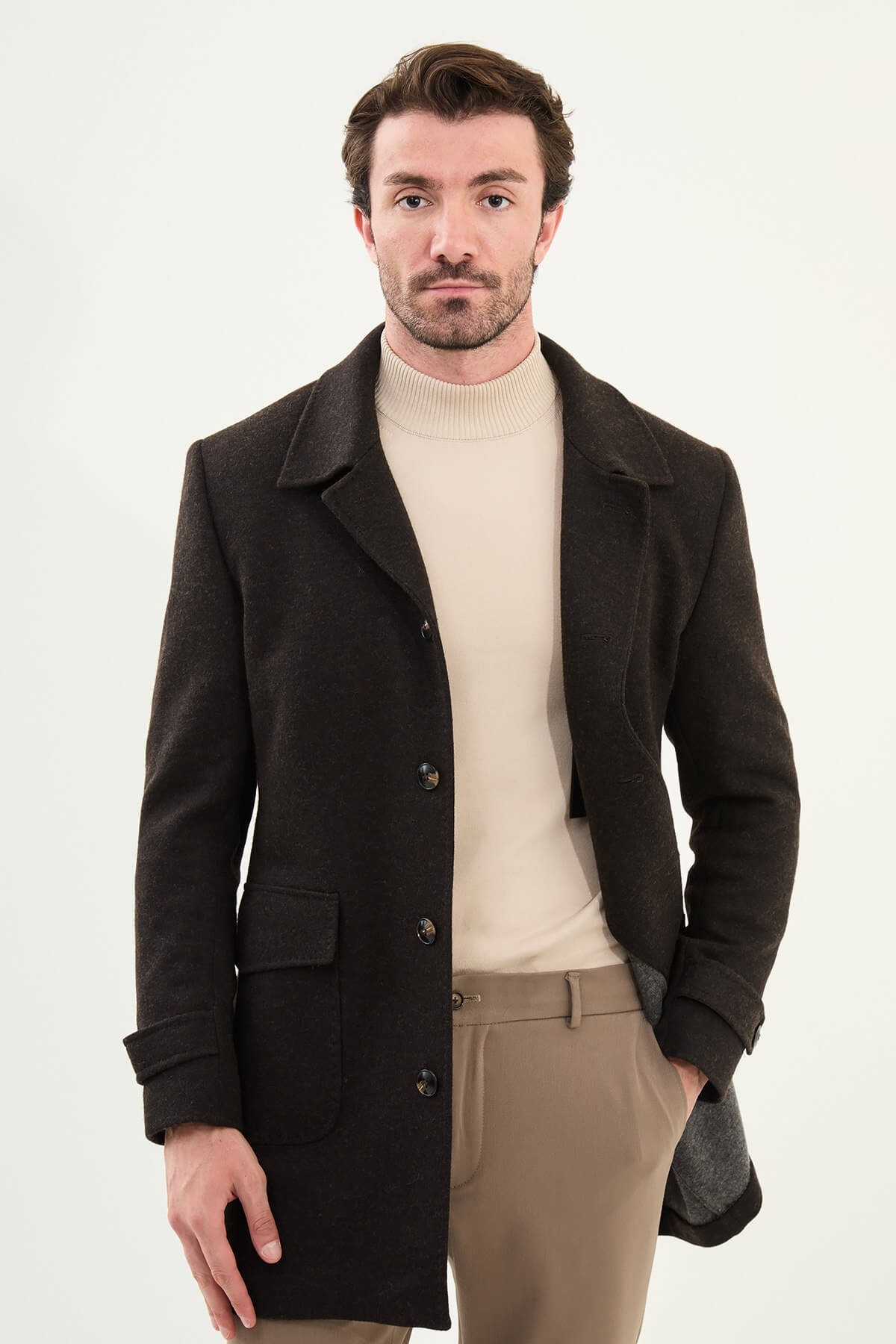 brown slim fit peacoat styled with beige turtleneck, brown trousers, and brown Chelsea boots.