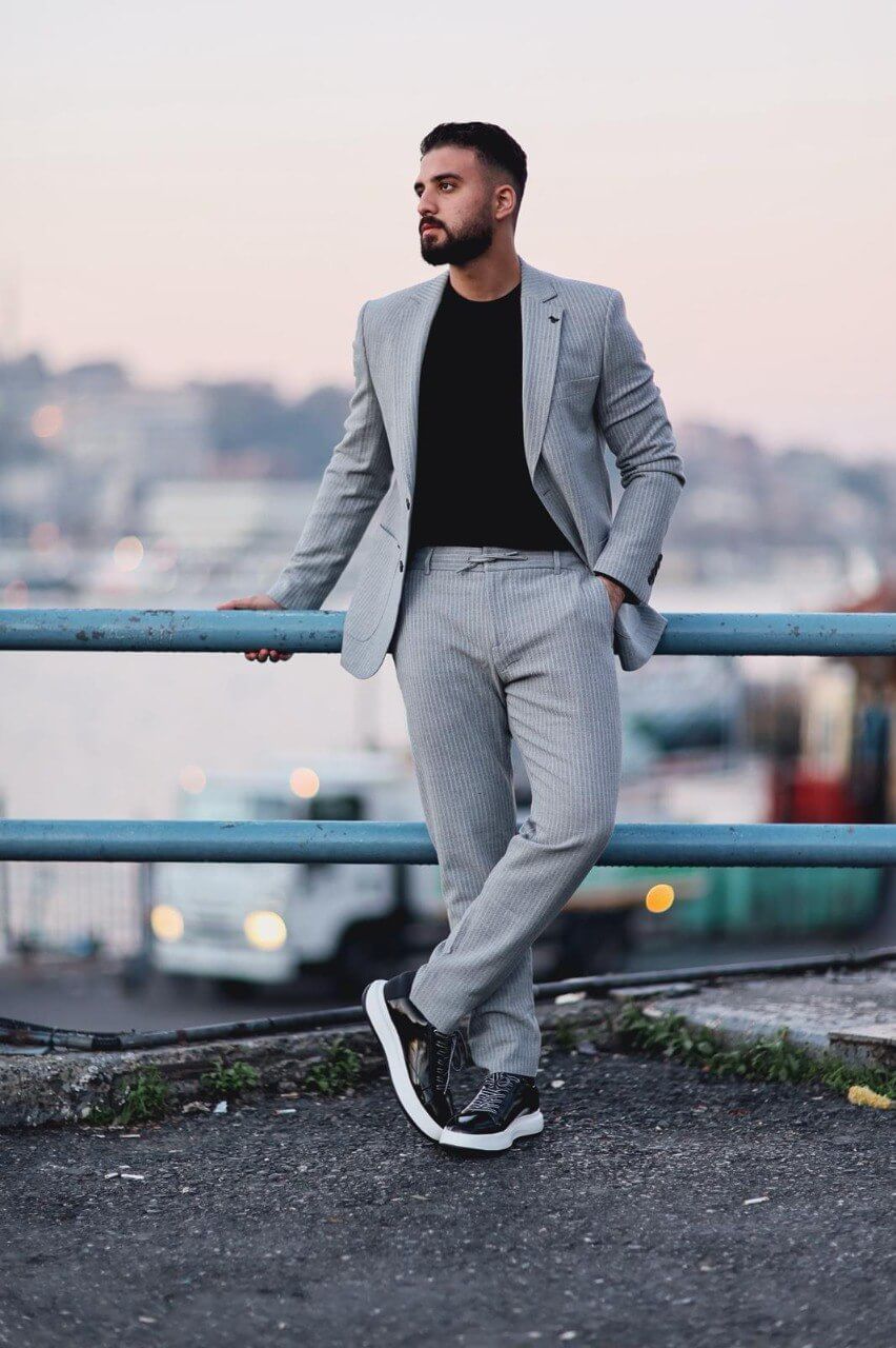 Men’s gray slim-fit mono-collar sport suit with subtle pinstripes styled with black tee and sneakers