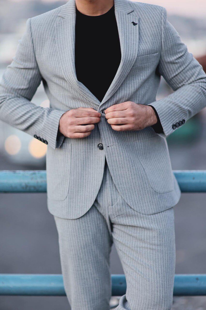 Men’s gray slim-fit mono-collar sport suit with subtle pinstripes styled with black tee and sneakers