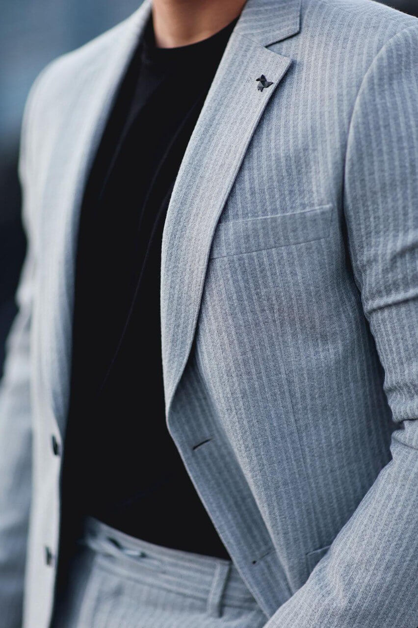 Men’s gray slim-fit mono-collar sport suit with subtle pinstripes styled with black tee and sneakers