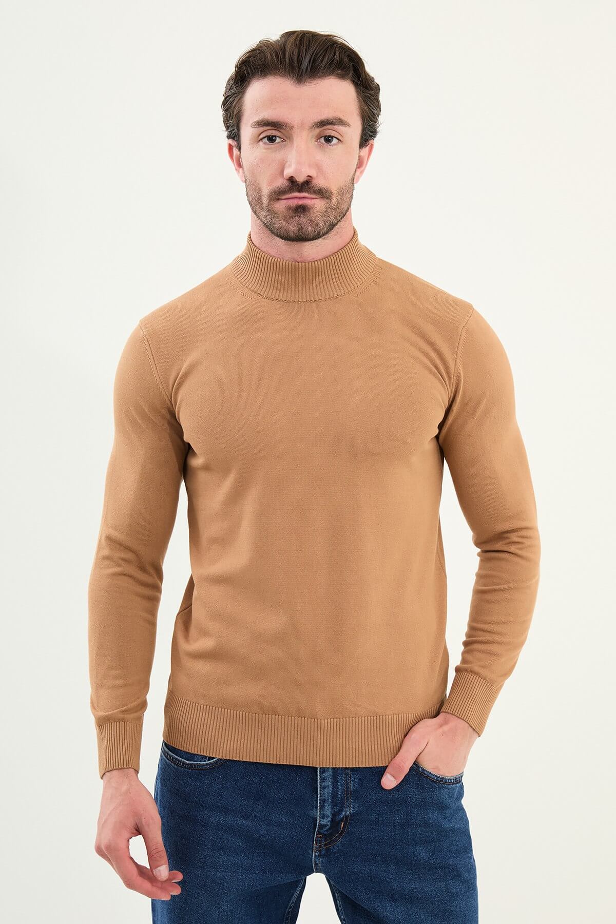 Man wearing a slim fit camel mock neck sweater with ribbed collar, cuffs, and hem.