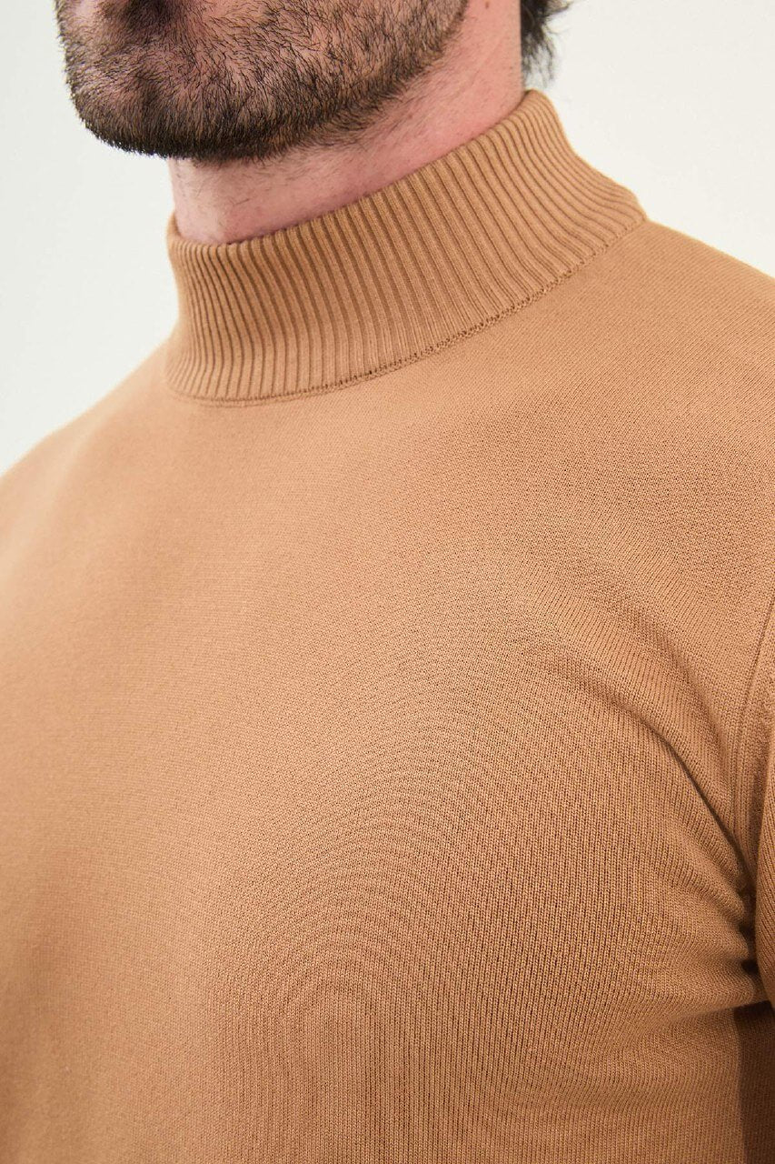 Man wearing a slim fit camel mock neck sweater with ribbed collar, cuffs, and hem.