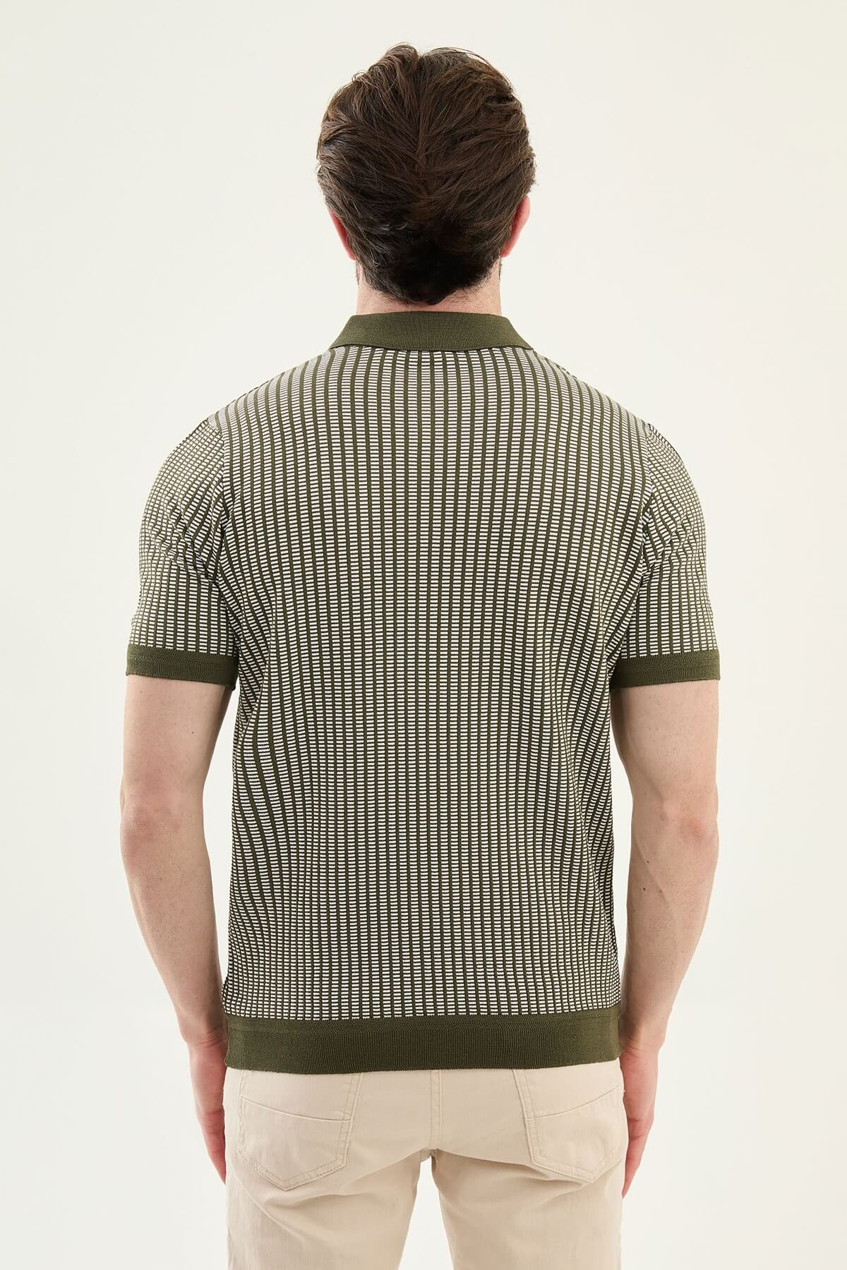 Men’s white striped slim fit knit polo shirt styled with dark trousers for an elegant summer smart-casual outfit.