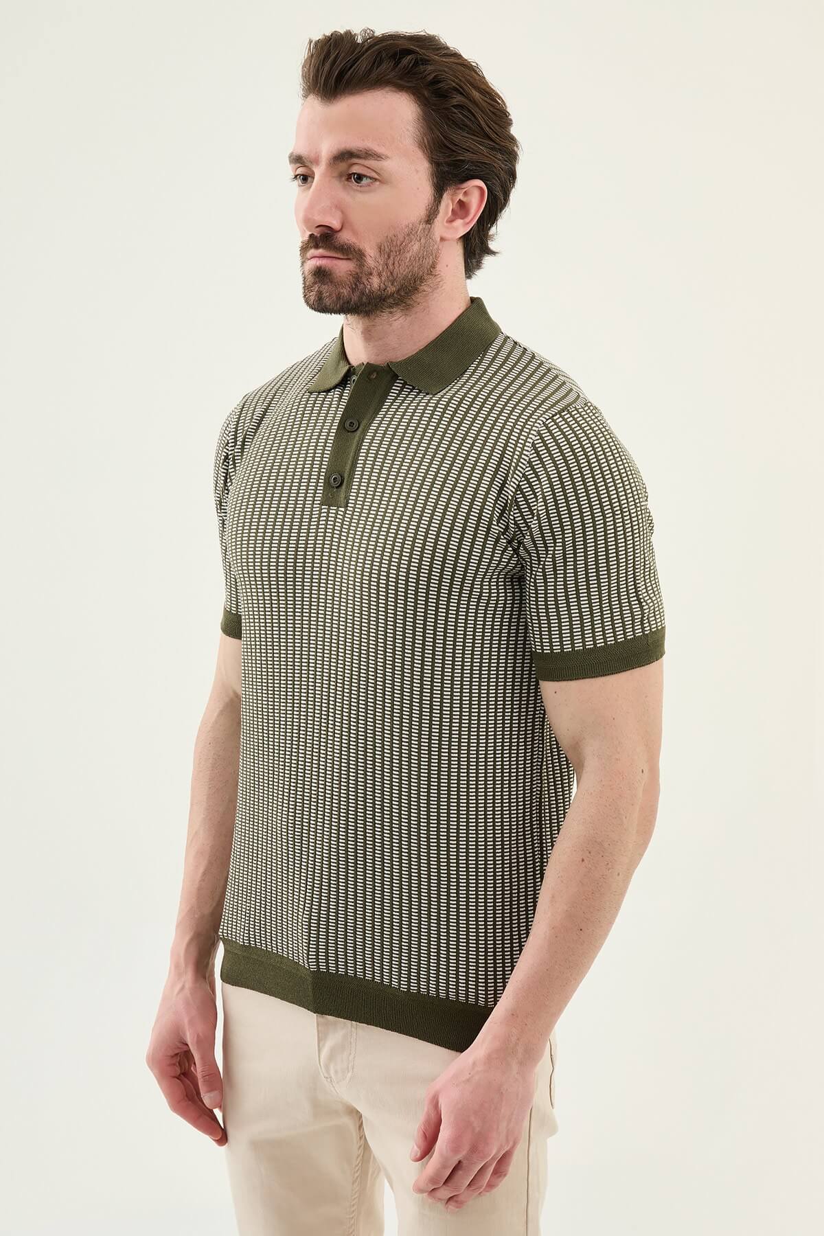 Men’s white striped slim fit knit polo shirt styled with dark trousers for an elegant summer smart-casual outfit.