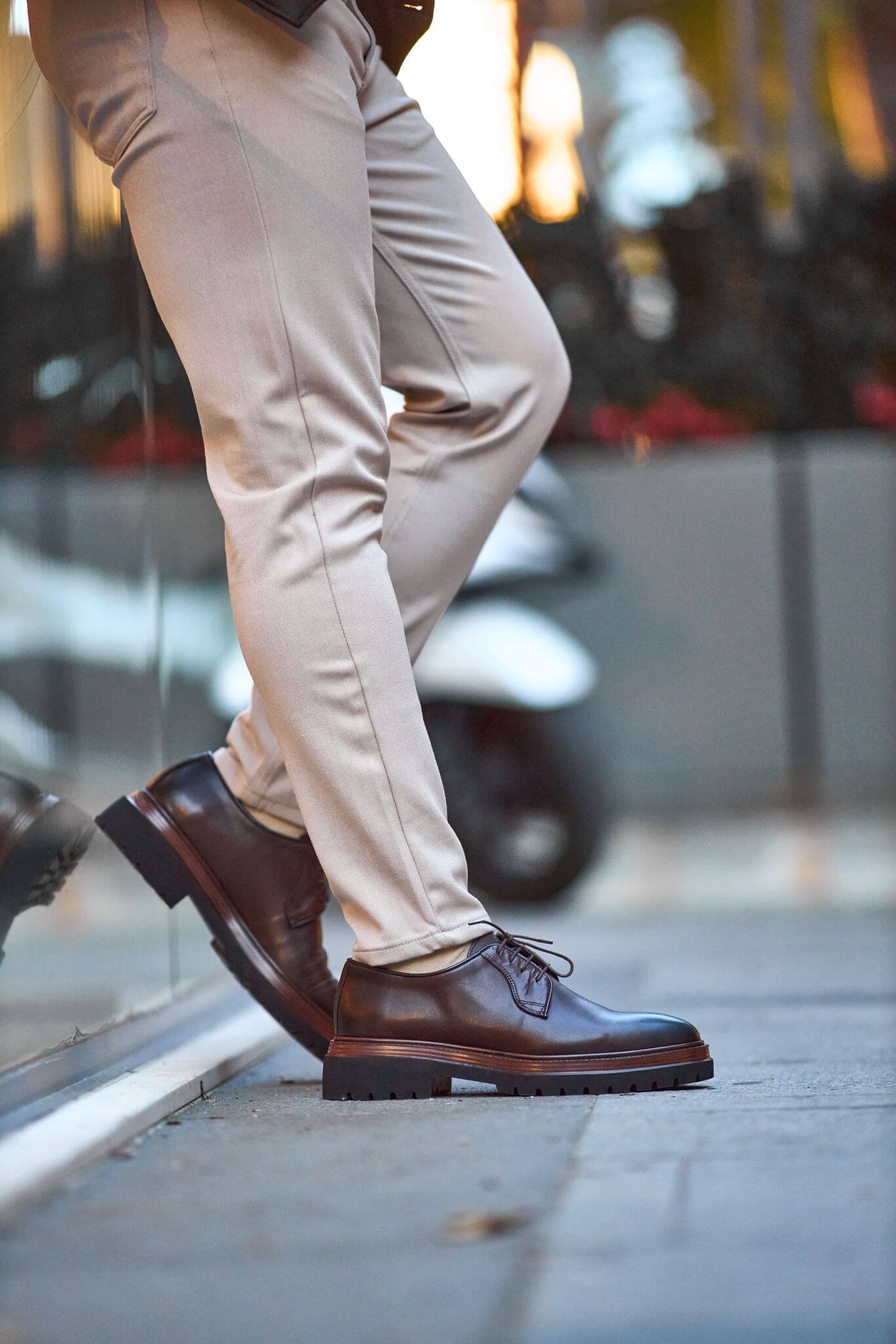 Men’s brown genuine leather chunky Derby shoes worn outdoors on pavement.