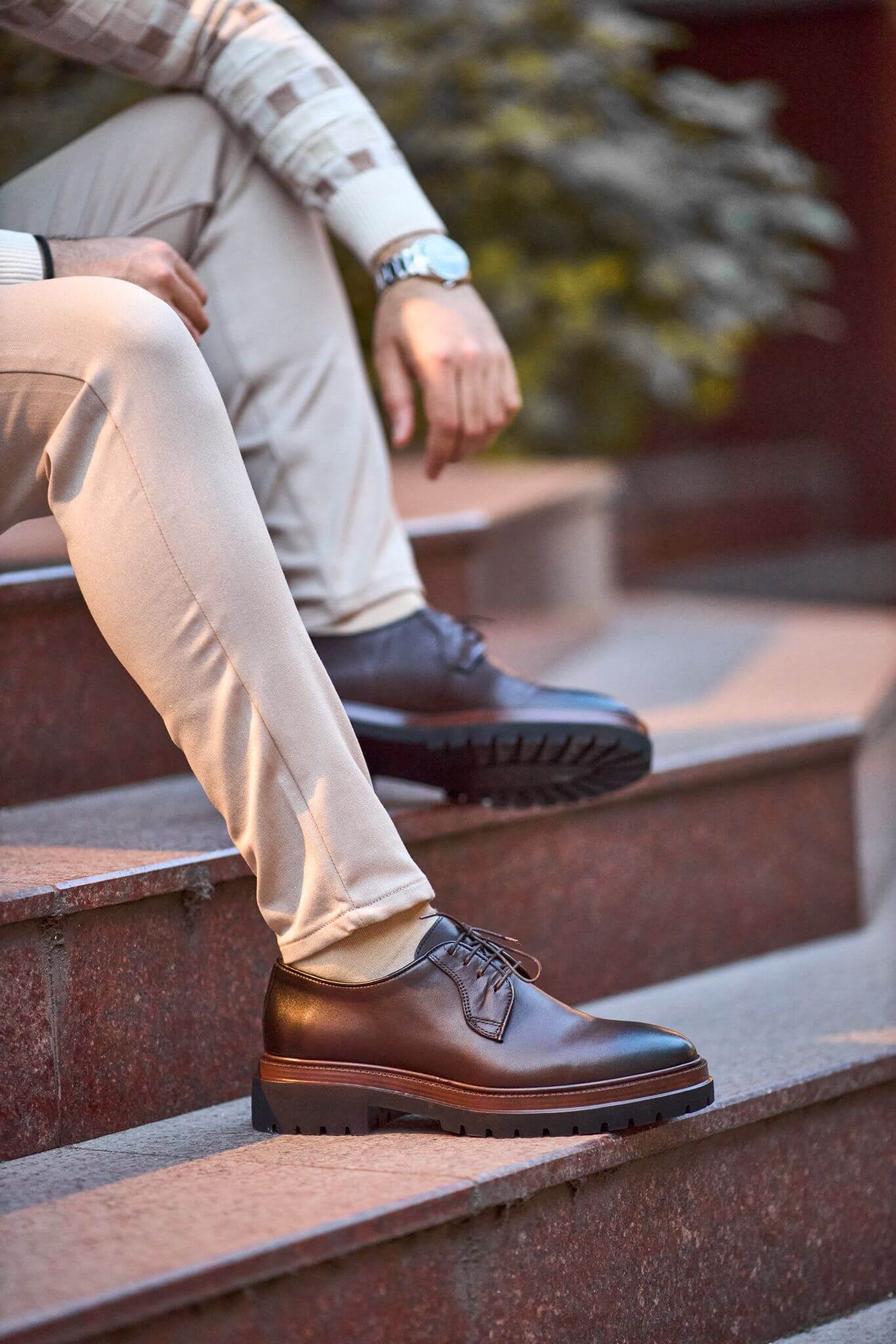 Men’s brown genuine leather chunky Derby shoes worn outdoors on pavement.