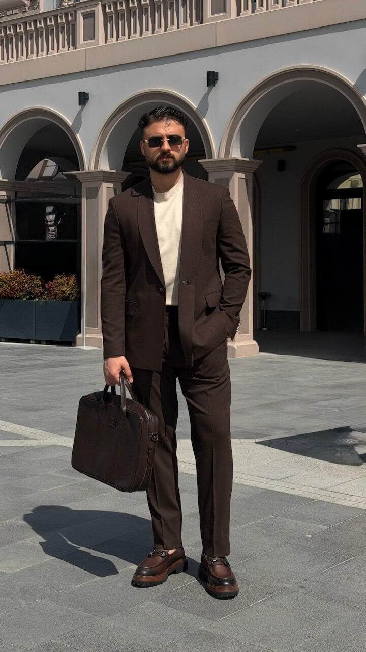 Men’s brown slim fit tailored suit with modern structure, styled with loafers and minimal outfit