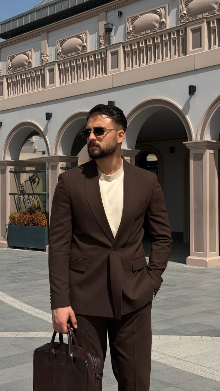 Men’s brown slim fit tailored suit with modern structure, styled with loafers and minimal outfit