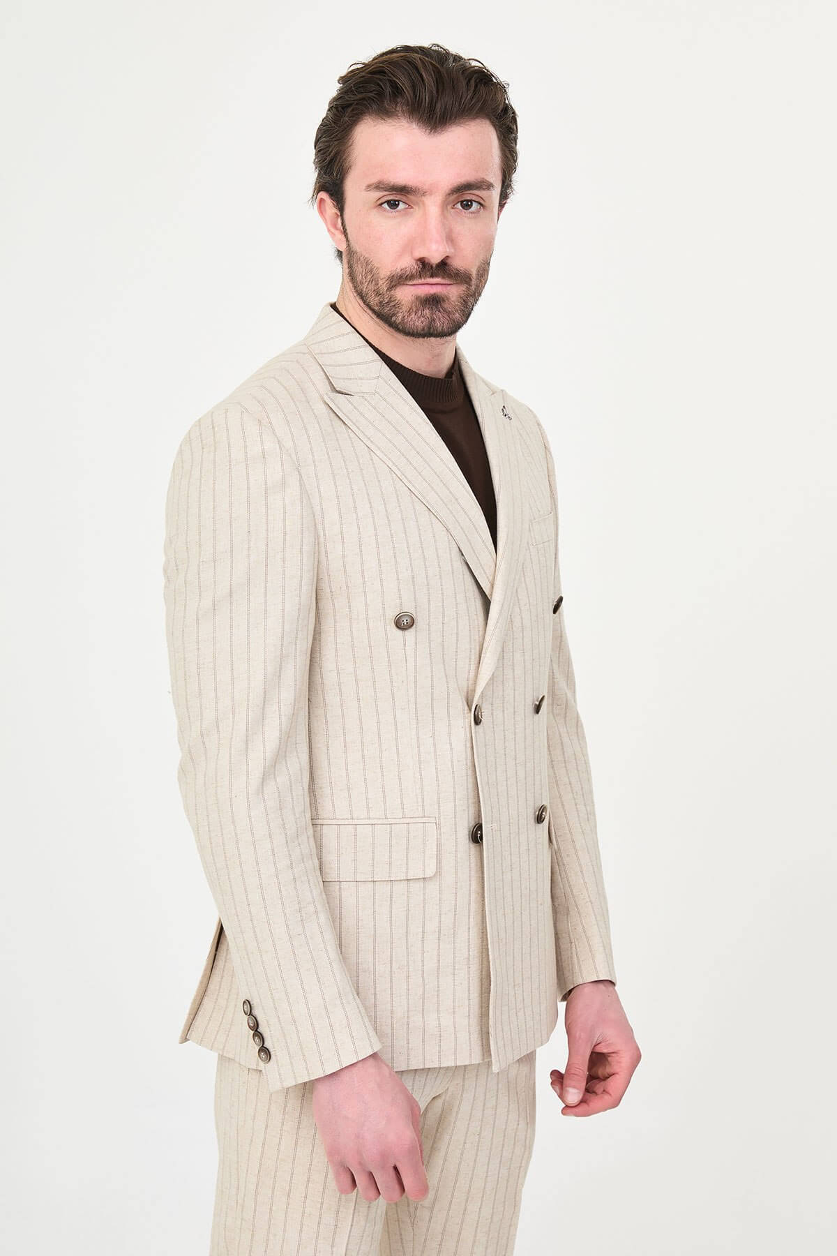 A man wearing a Beige Pinstripe Double-Breasted Slim-Fit Suit with a tailored fit, standing confidently.