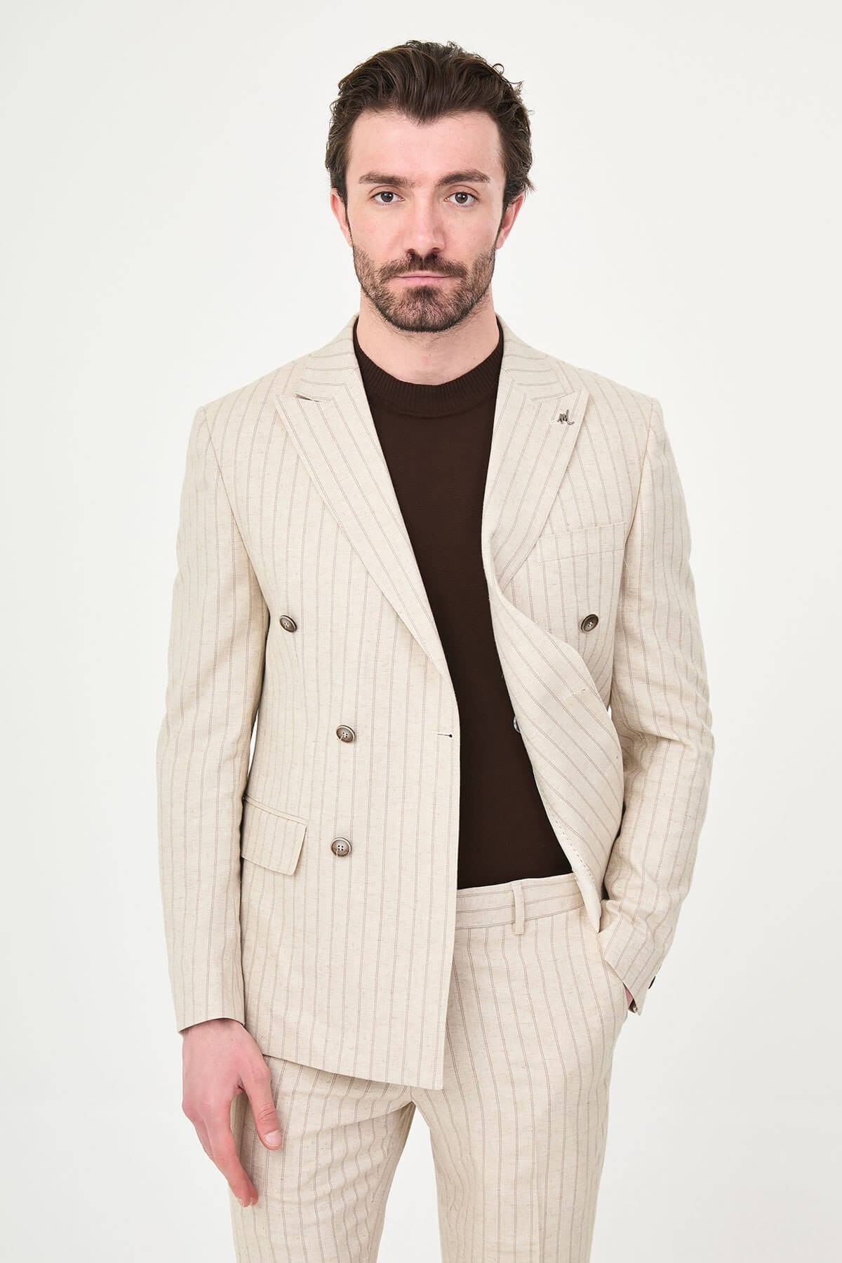 A man wearing a Beige Pinstripe Double-Breasted Slim-Fit Suit with a tailored fit, standing confidently.