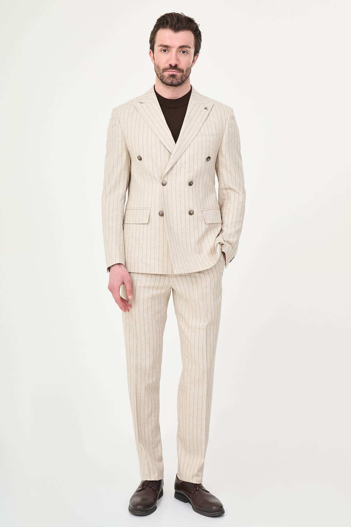 A man wearing a Beige Pinstripe Double-Breasted Slim-Fit Suit with a tailored fit, standing confidently.