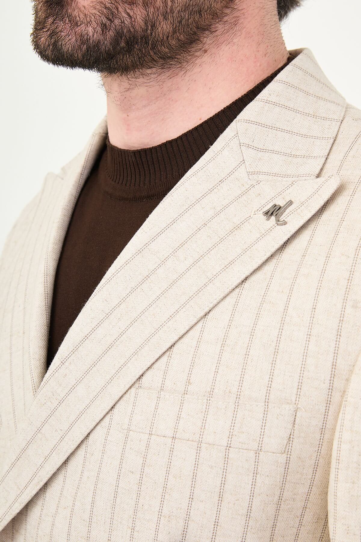 A man wearing a Beige Pinstripe Double-Breasted Slim-Fit Suit with a tailored fit, standing confidently.