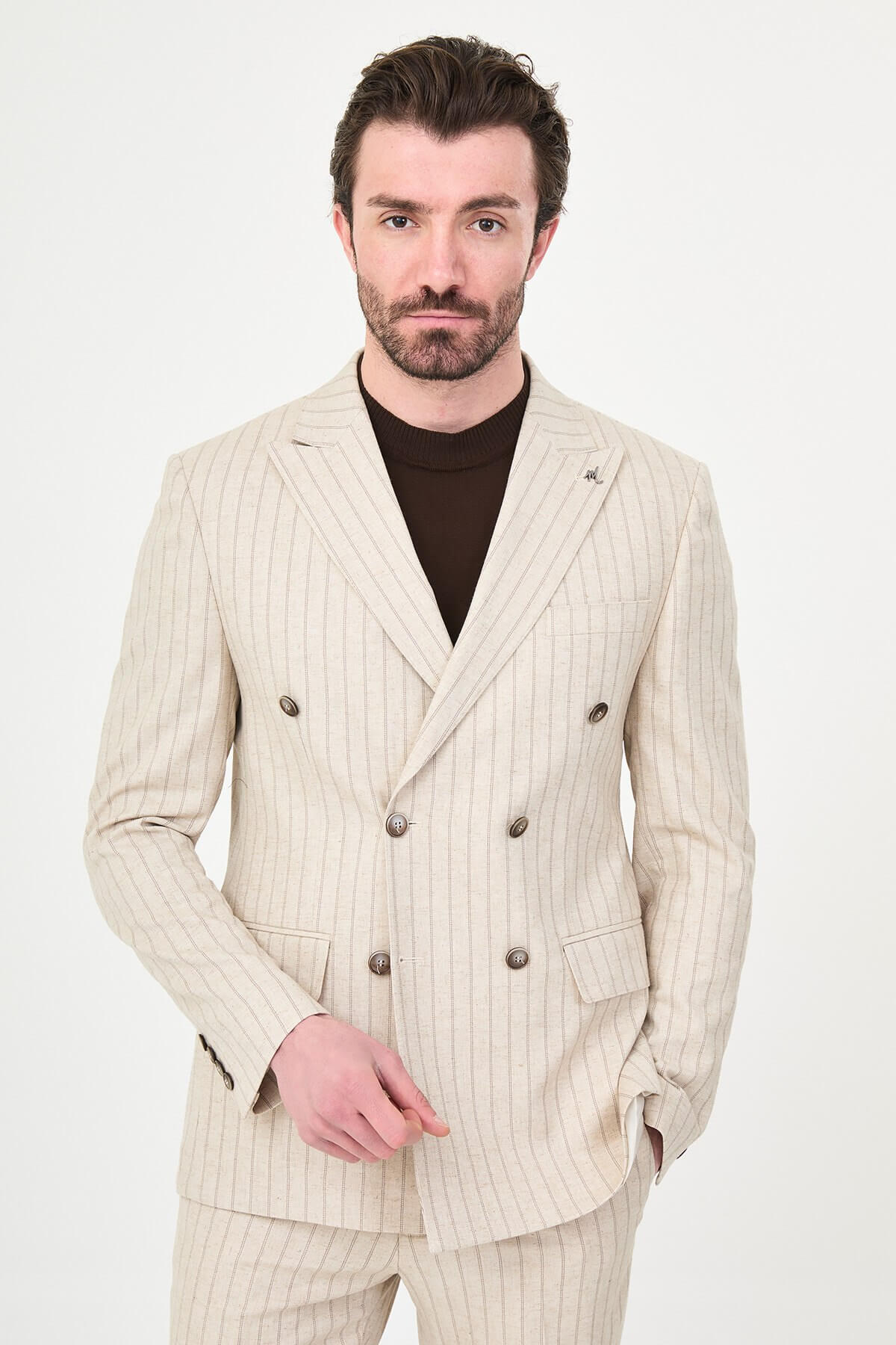 A man wearing a Beige Pinstripe Double-Breasted Slim-Fit Suit with a tailored fit, standing confidently.