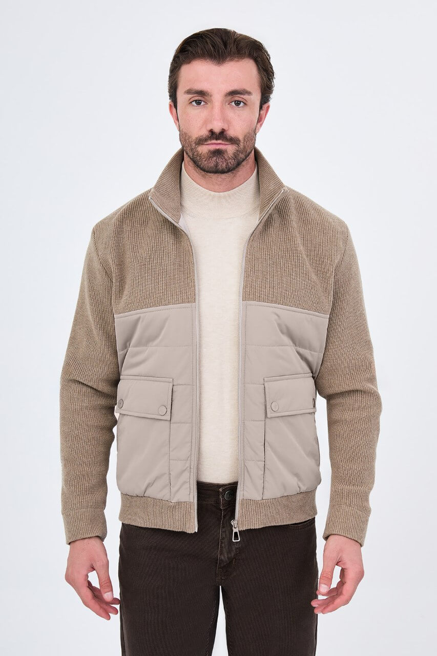 Beige men's casual jacket styled with a cream sweater and dark trousers.