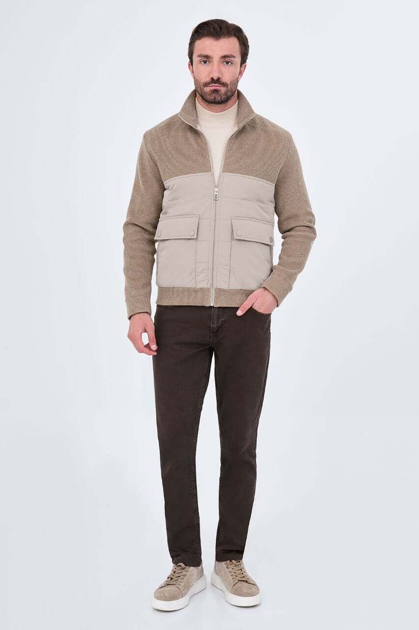 Beige men's casual jacket styled with a cream sweater and dark trousers.