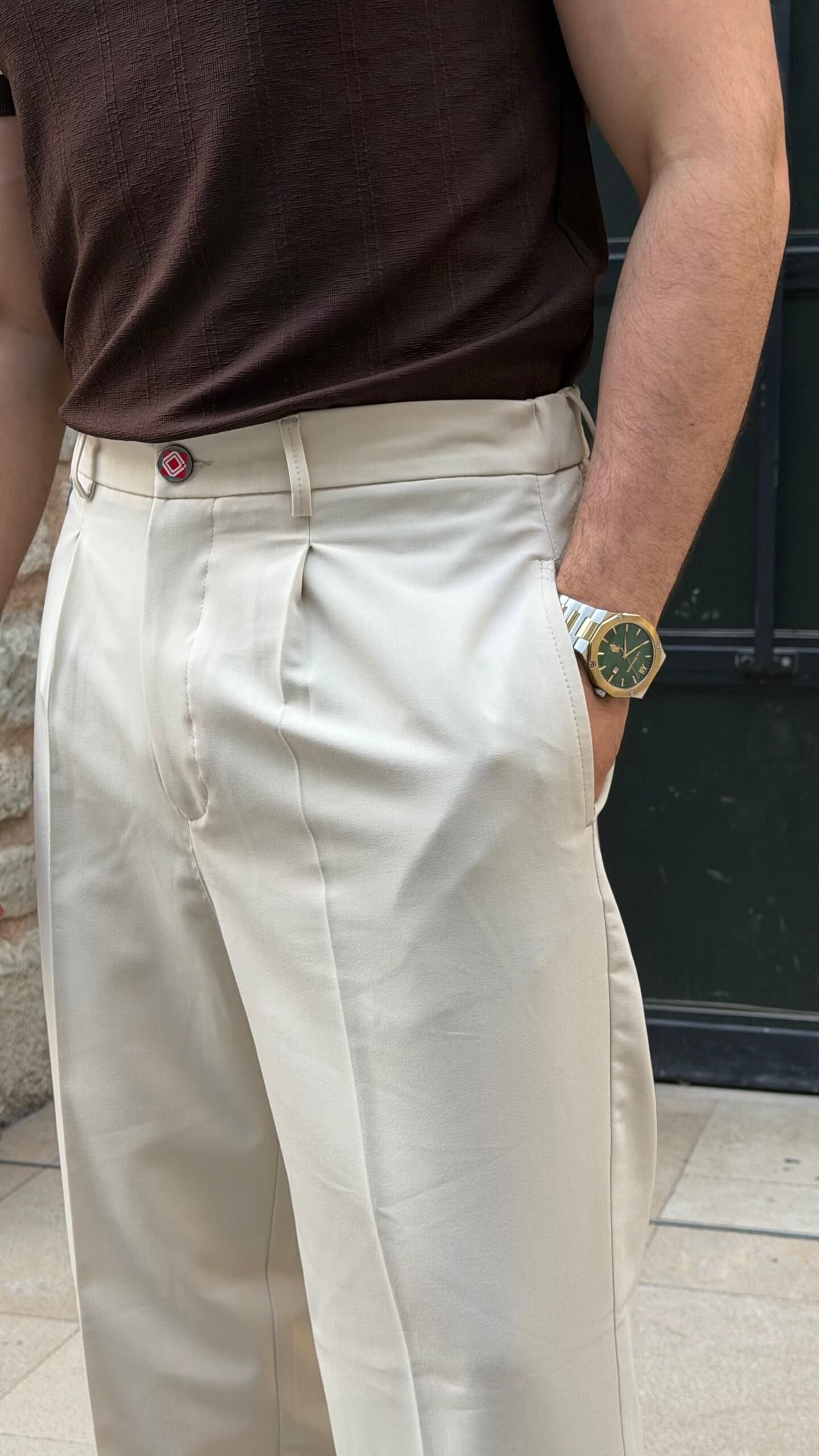 Beige pleated trousers showing front pleats and waistband, close-up