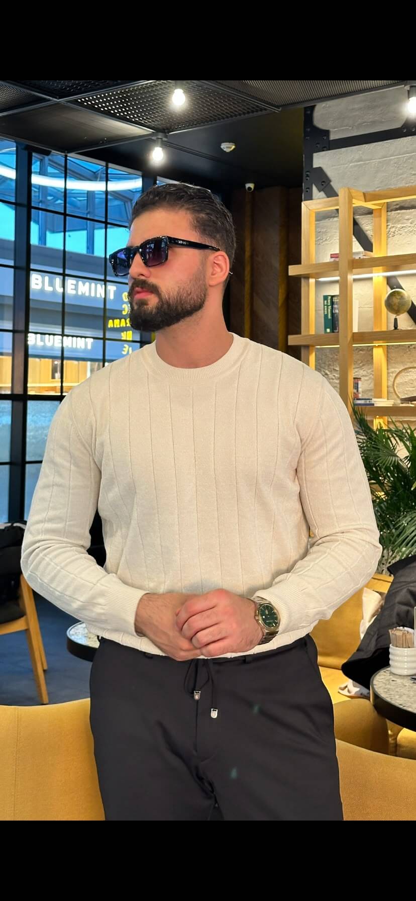 Men’s ecru ribbed crewneck cotton sweater styled with black trousers for fall winter fashion