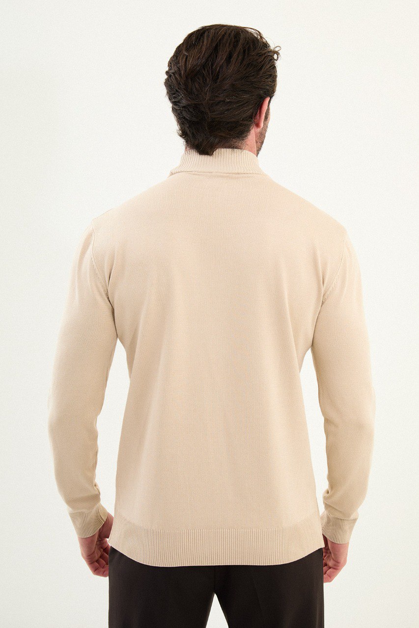 Men’s beige slim-fit ribbed mock-neck cotton-blend sweater with multi-directional ribbing and diagonal chest panels, styled with dark trousers.
