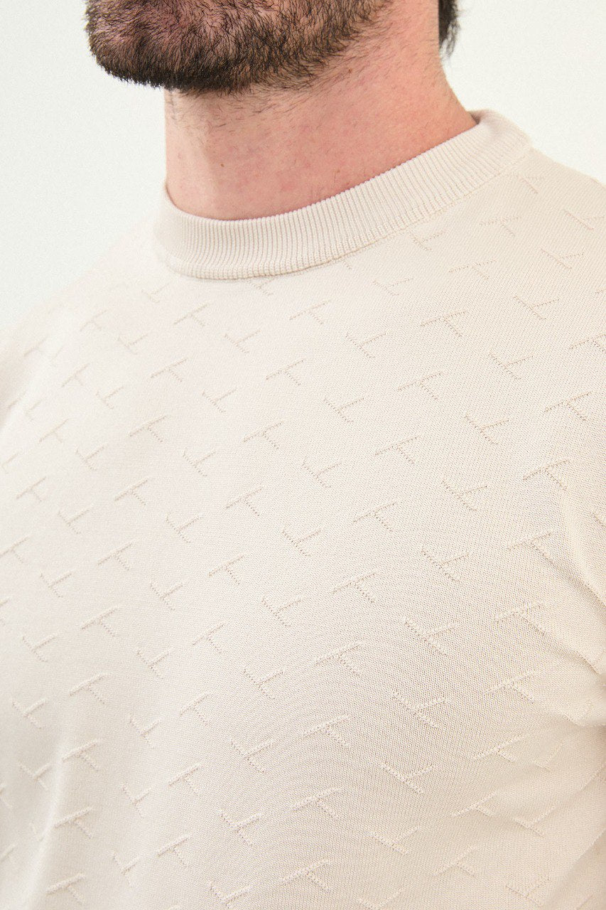 Men’s beige slim-fit crew-neck sweater with geometric ‘T’ textured knit front panel, ribbed collar, cotton-viscose-elastane blend, styled with dark corduroy trousers.