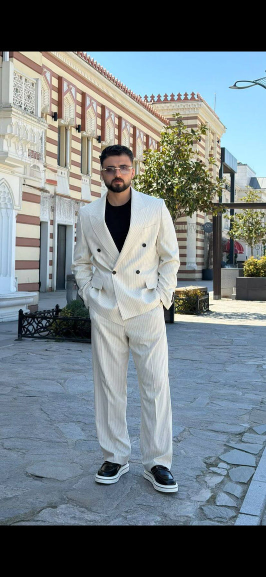 Men wearing beige shawl lapel slim-fit suit with matching trousers, styled outdoors, front view.