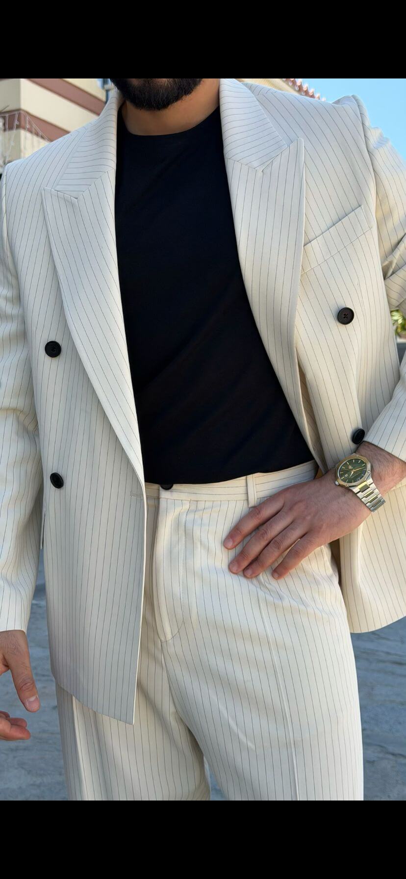 Men wearing beige shawl lapel slim-fit suit with matching trousers, styled outdoors, front view.