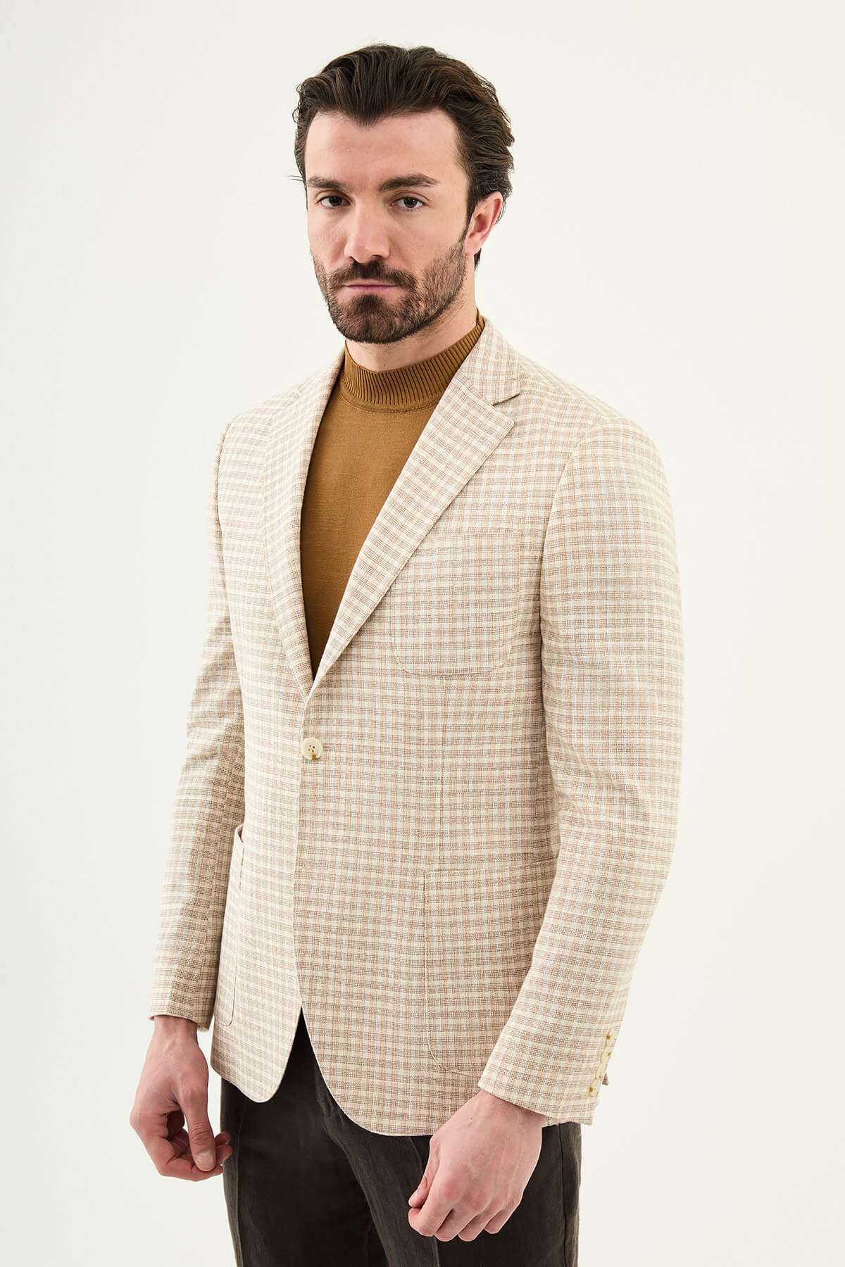 Men’s beige slim fit cotton linen blazer with a lightweight textured pattern, styled for smart casual and elegant summer occasions.