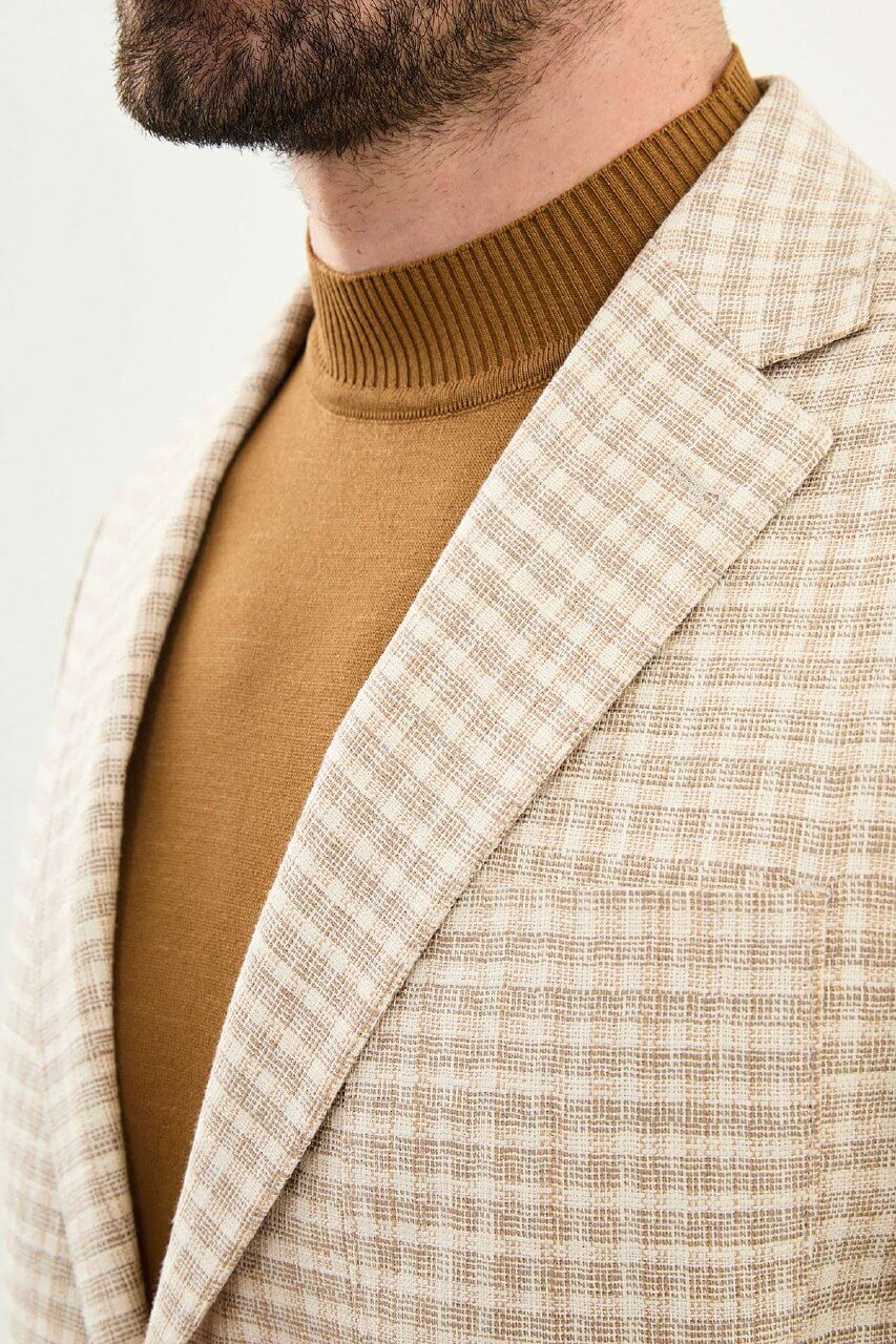 Men’s beige slim fit cotton linen blazer with a lightweight textured pattern, styled for smart casual and elegant summer occasions.