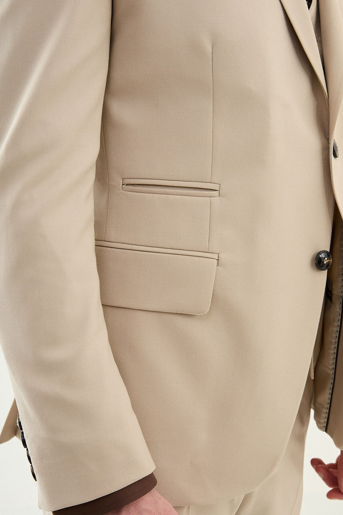 Beige slim-fit three-piece men’s suit with brown shirt and patterned tie