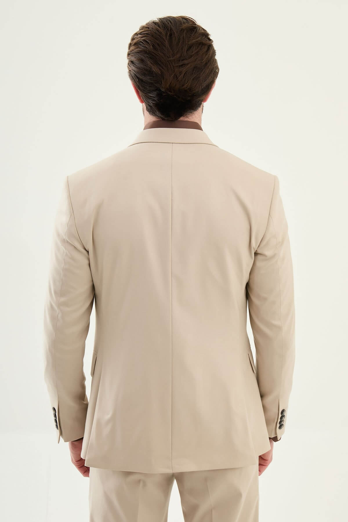 Beige slim-fit three-piece men’s suit with brown shirt and patterned tie