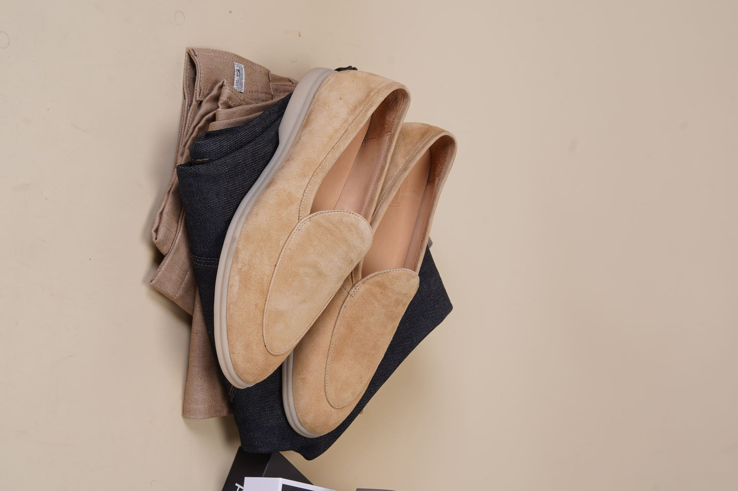 Men’s beige suede slip-on loafers featuring a minimalist apron vamp design and lightweight cream sole, perfect for smart-casual summer outfits.