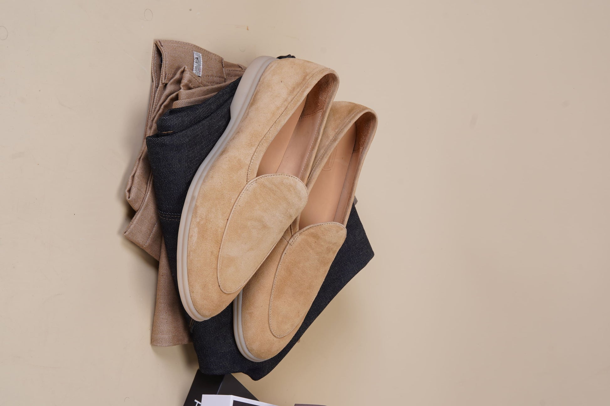Men’s beige suede slip-on loafers featuring a minimalist apron vamp design and lightweight cream sole, perfect for smart-casual summer outfits.