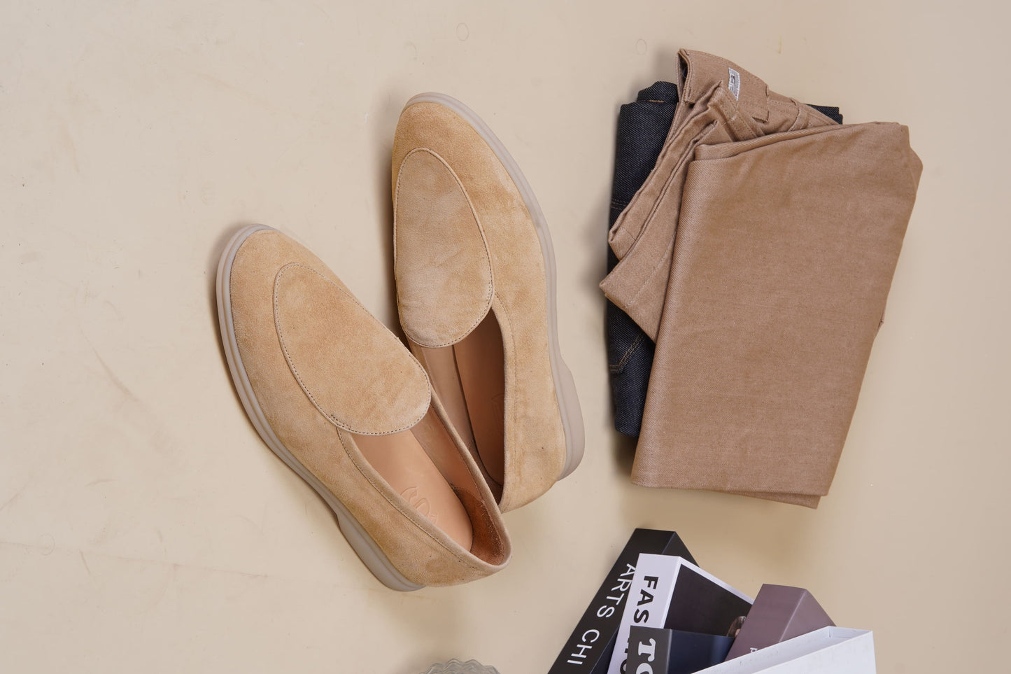 Men’s beige suede slip-on loafers featuring a minimalist apron vamp design and lightweight cream sole, perfect for smart-casual summer outfits.