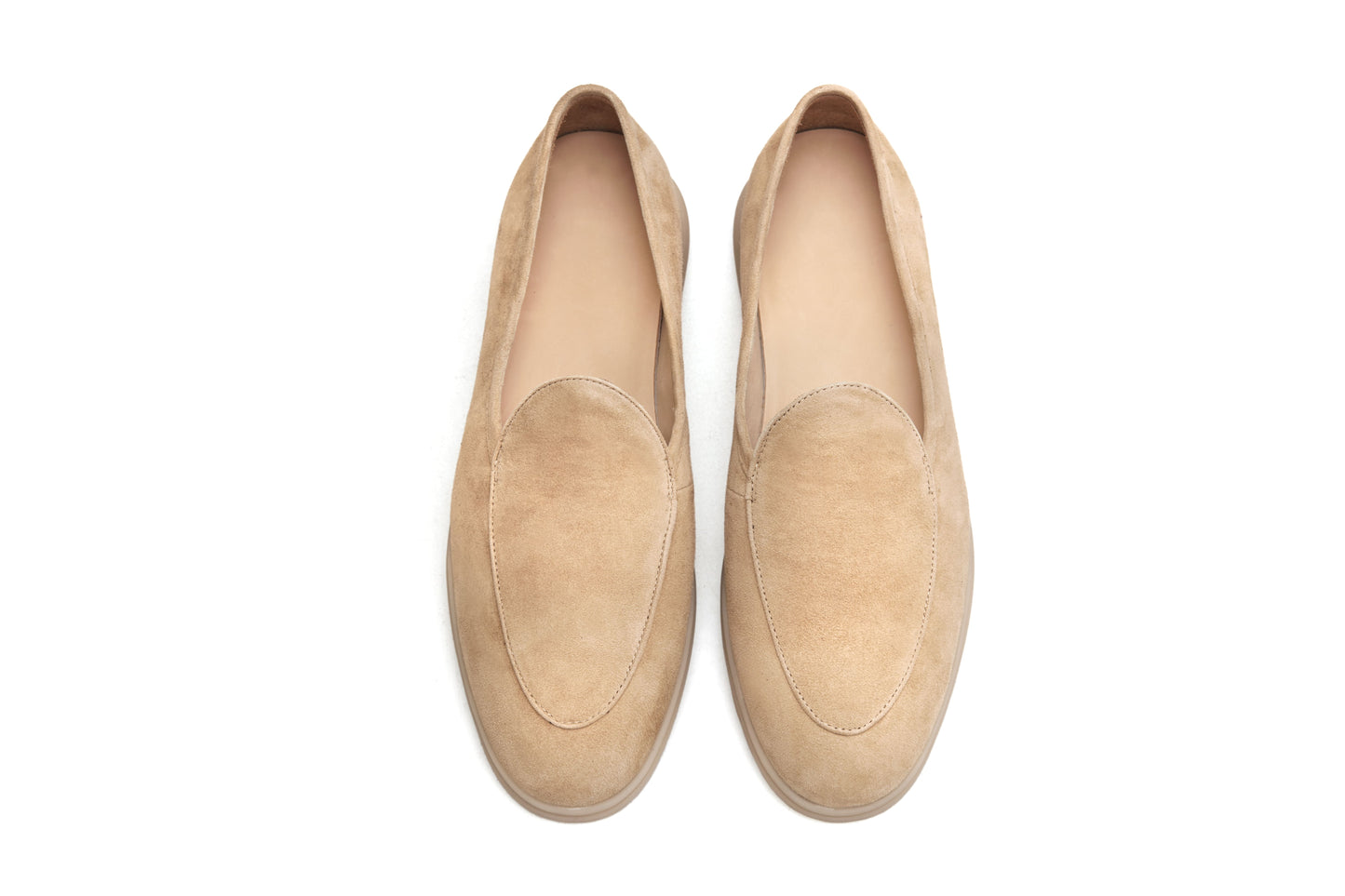 Men’s beige suede slip-on loafers featuring a minimalist apron vamp design and lightweight cream sole, perfect for smart-casual summer outfits.