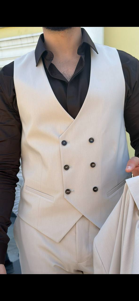 beige three-piece slim-fit suit showing the tailored jacket and waistcoat details with black shirt, highlighting the fabric texture and fit.
