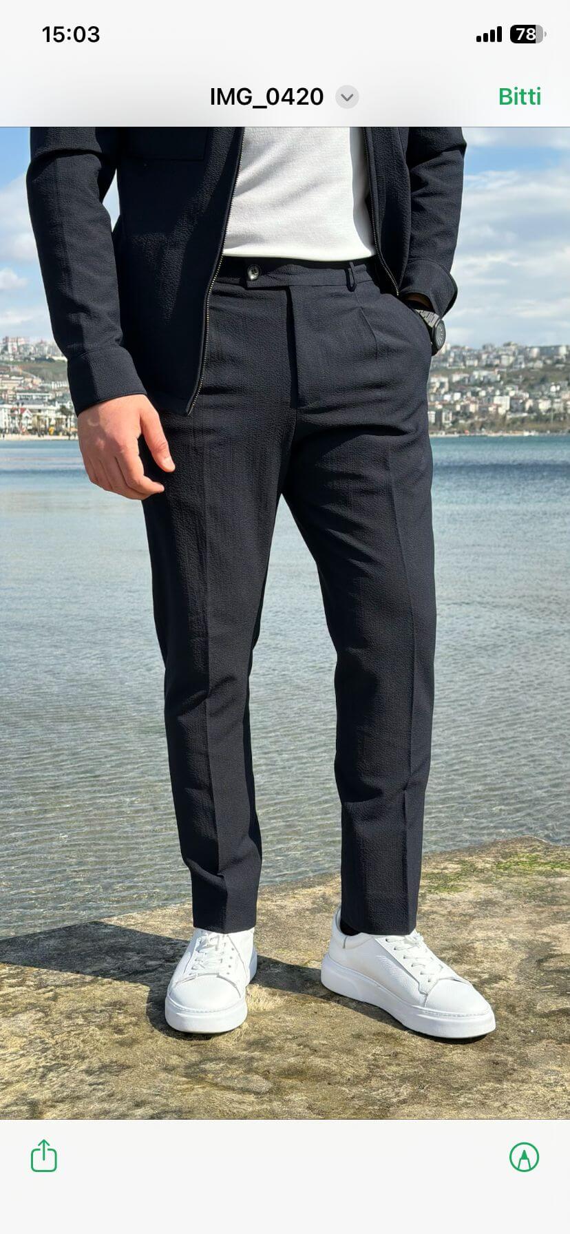 Men’s navy blue cargo co-set featuring a cargo shacket with multiple pockets and matching tracksuit pants, worn outdoors with white sneakers, showcasing a relaxed look.