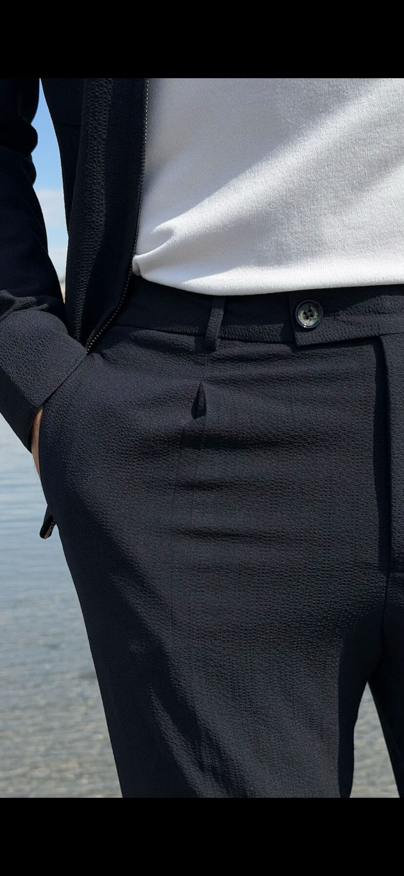 Men’s navy blue cargo co-set featuring a cargo shacket with multiple pockets and matching tracksuit pants, worn outdoors with white sneakers, showcasing a relaxed look.