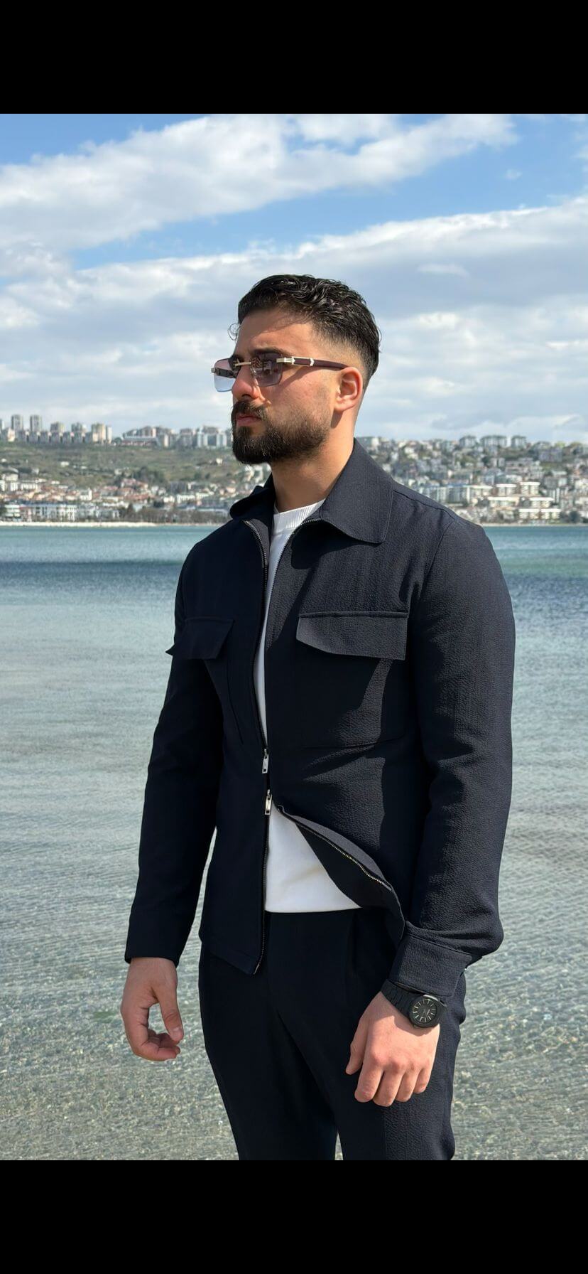 Men’s navy blue cargo co-set featuring a cargo shacket with multiple pockets and matching tracksuit pants, worn outdoors with white sneakers, showcasing a relaxed look.