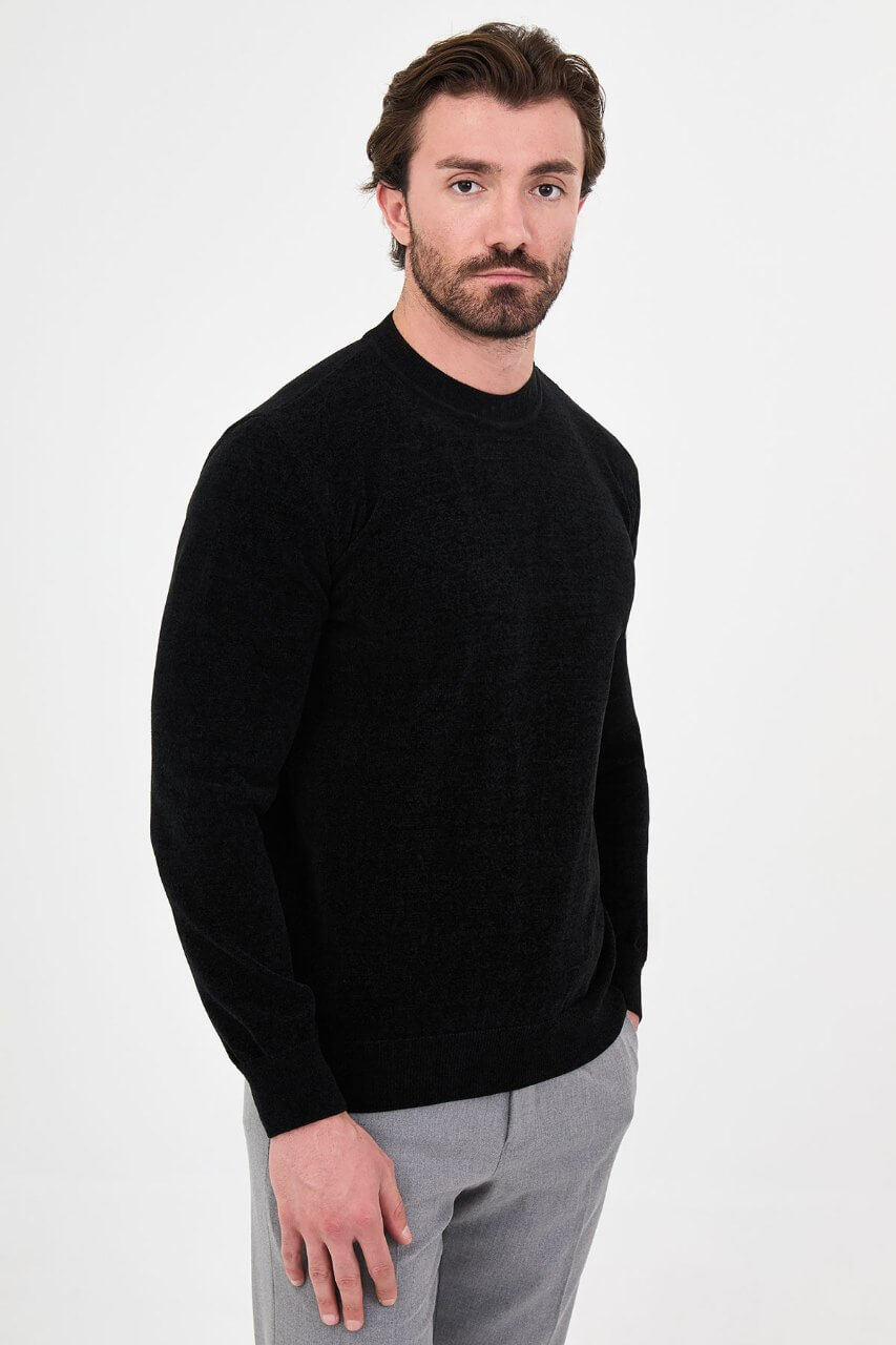 Men’s black crew neck knit sweater in a cotton blend slim fit design styled with grey trousers for a refined fall winter outfit.