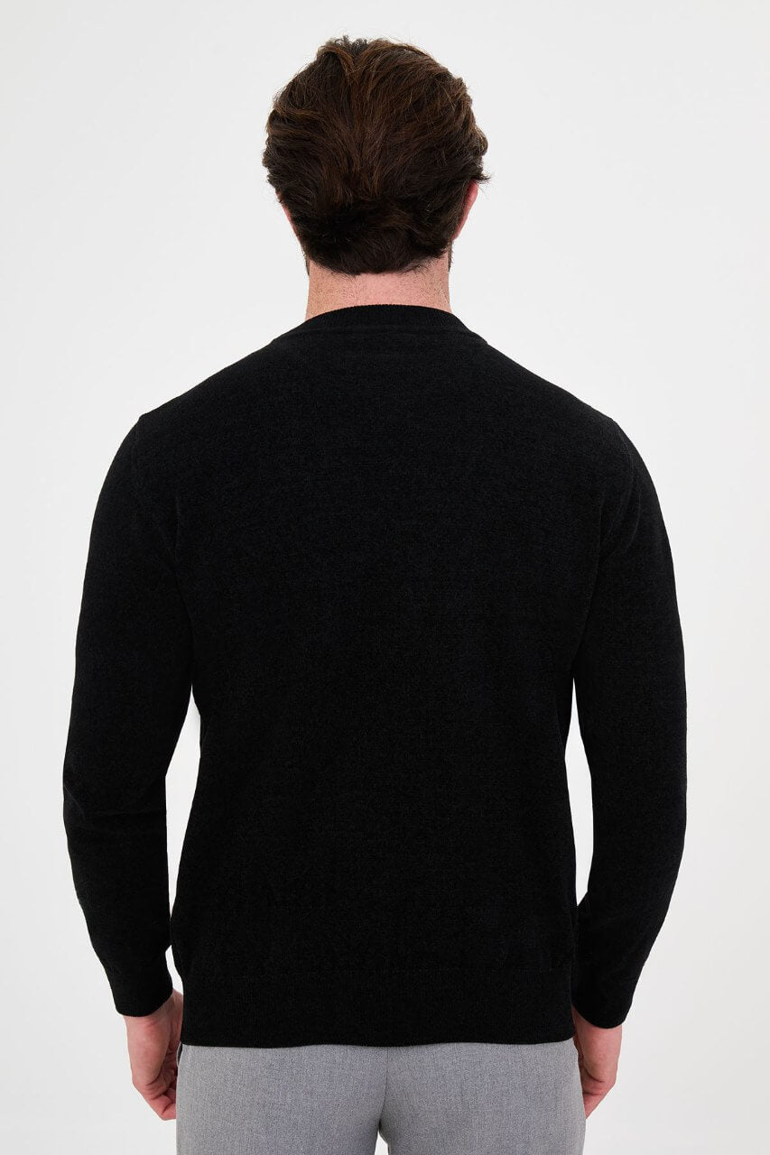 Men’s black crew neck knit sweater in a cotton blend slim fit design styled with grey trousers for a refined fall winter outfit.