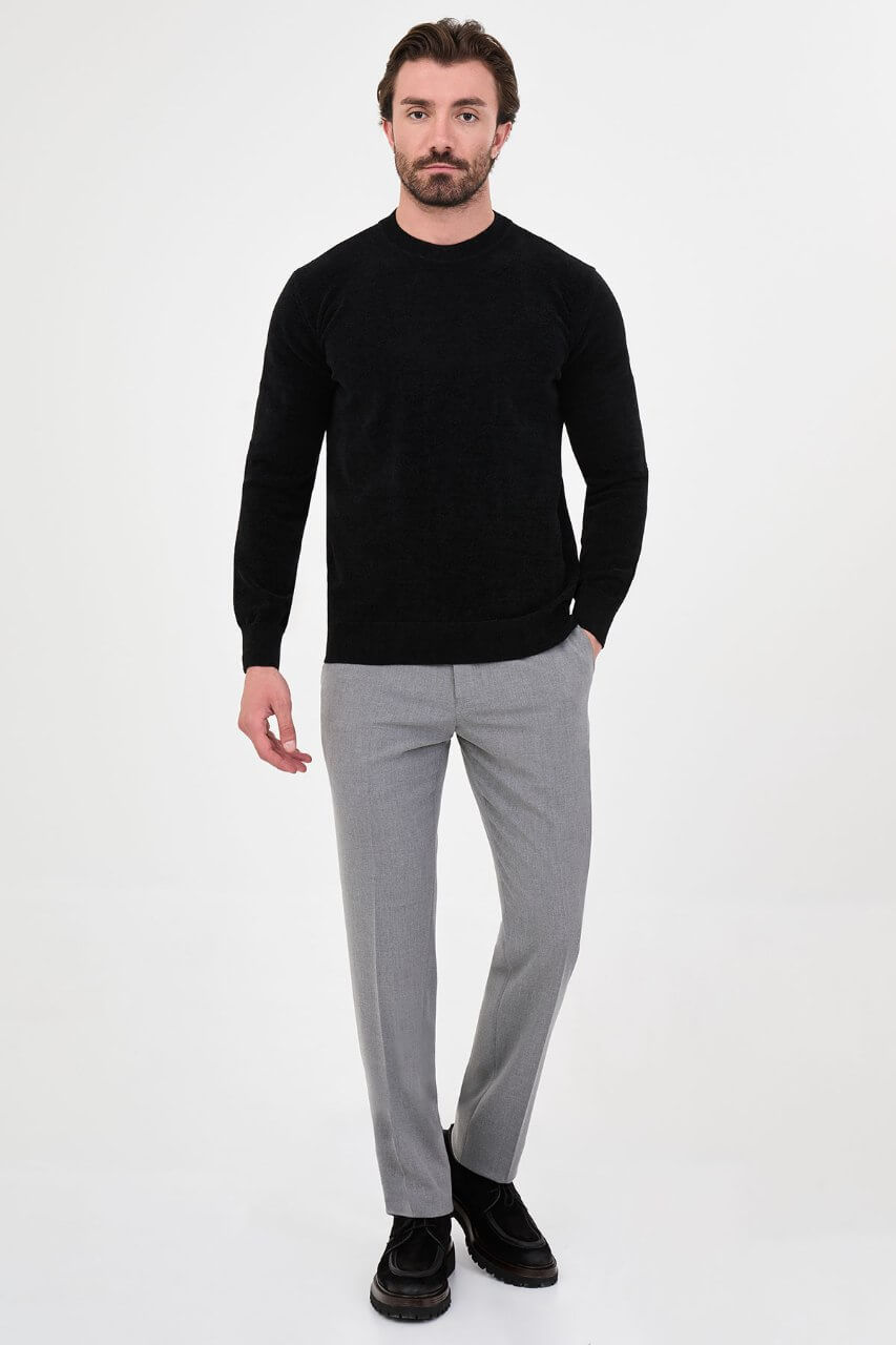 Men’s black crew neck knit sweater in a cotton blend slim fit design styled with grey trousers for a refined fall winter outfit.