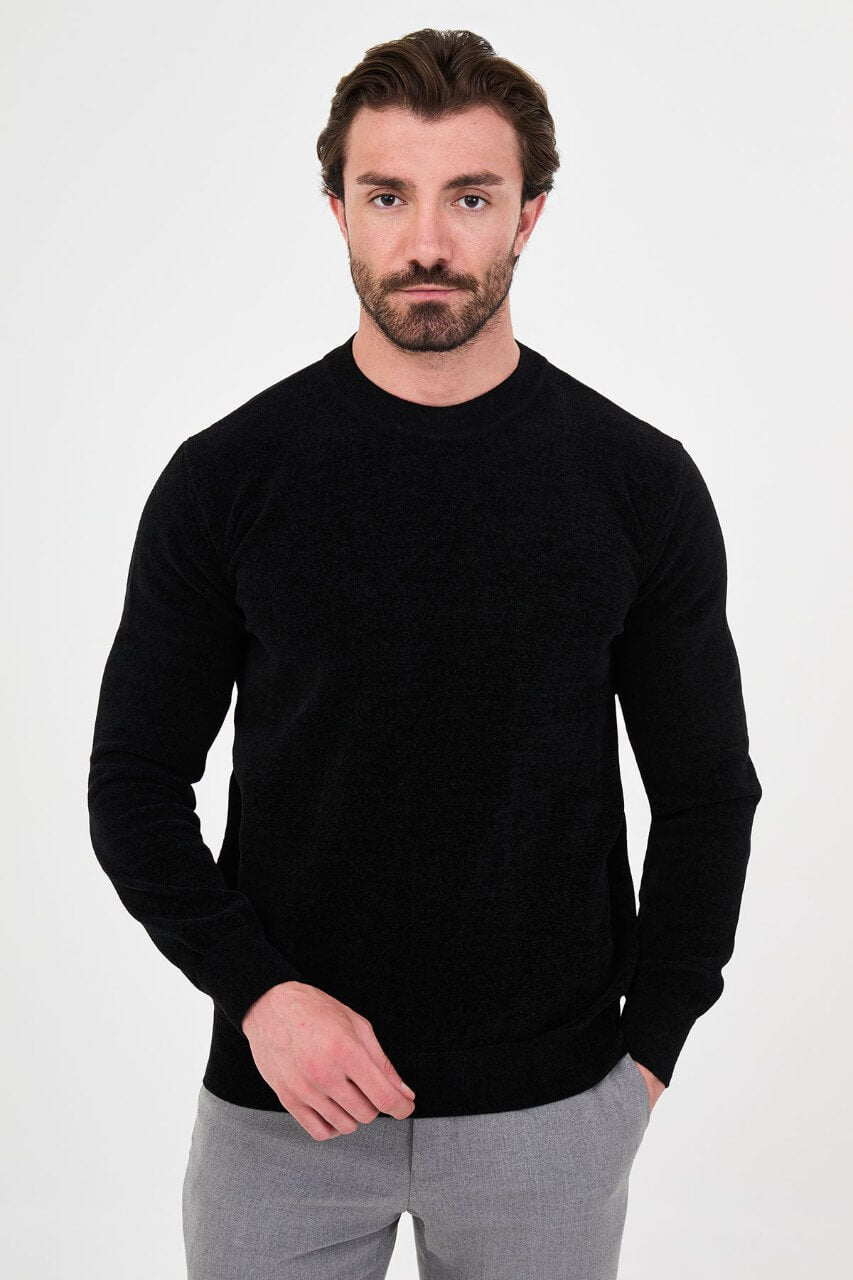 Men’s black crew neck knit sweater in a cotton blend slim fit design styled with grey trousers for a refined fall winter outfit.