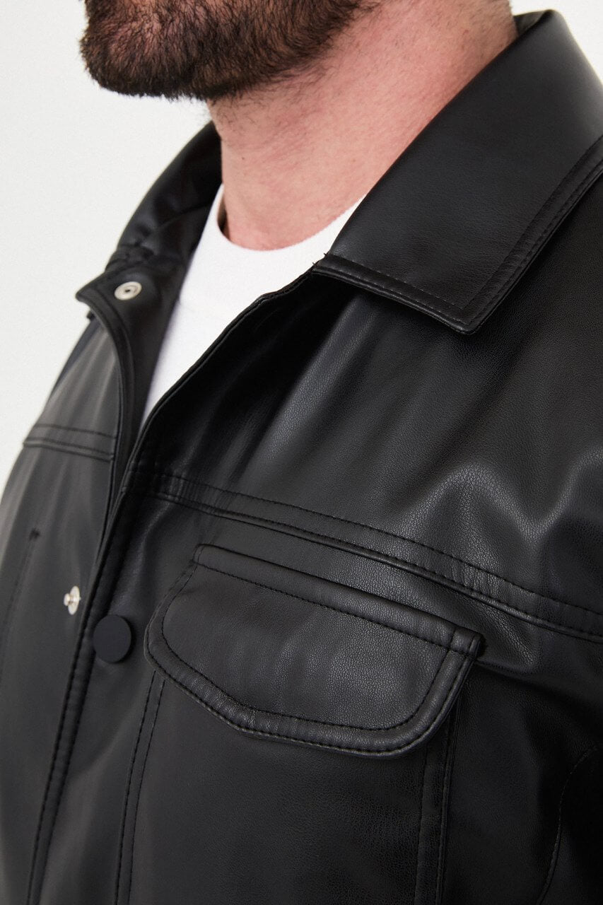 Men's black PU leather jacket styled with black trousers and a white crew-neck T-shirt.