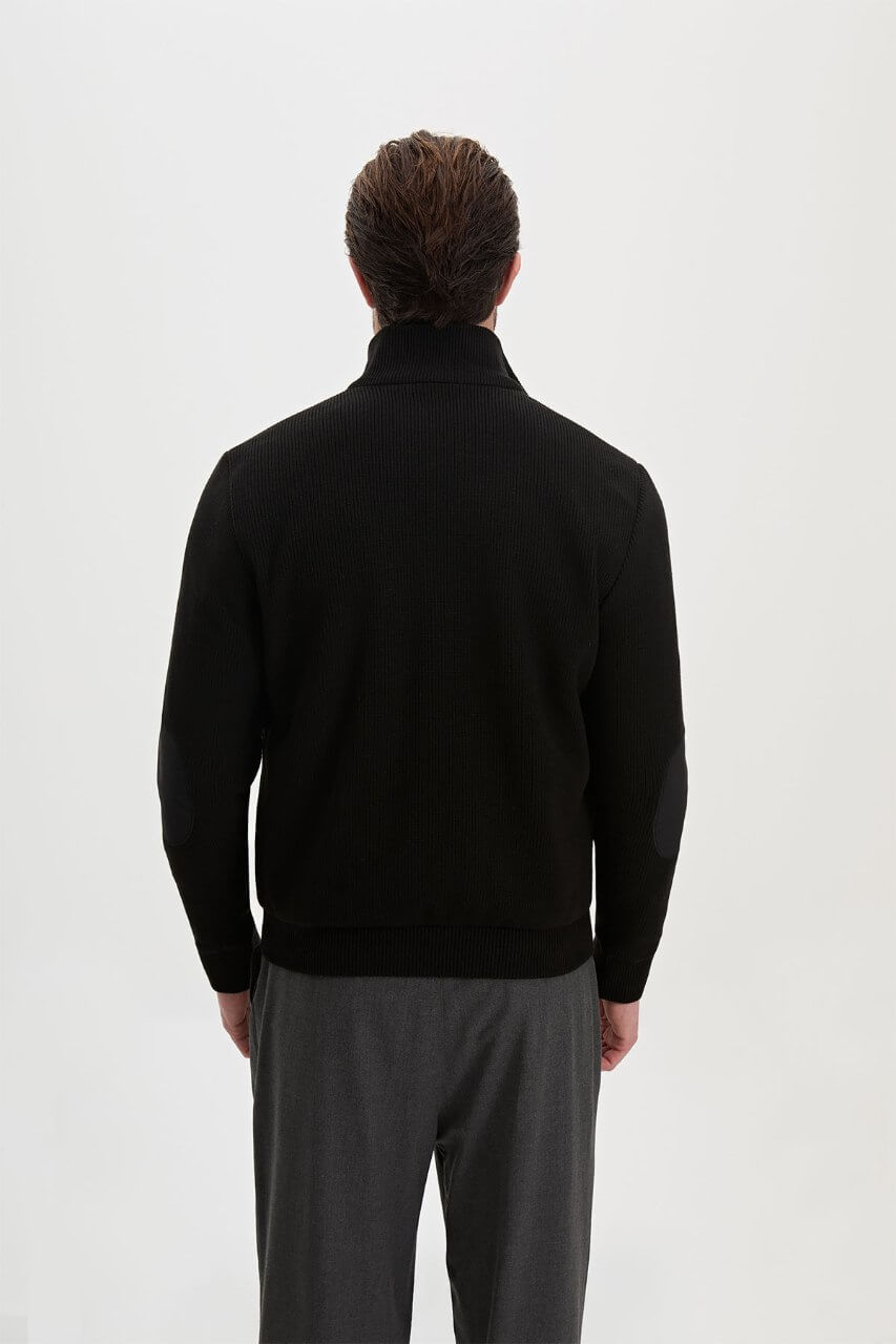 Black men's casual jacket styled with a white T-shirt and grey trousers.