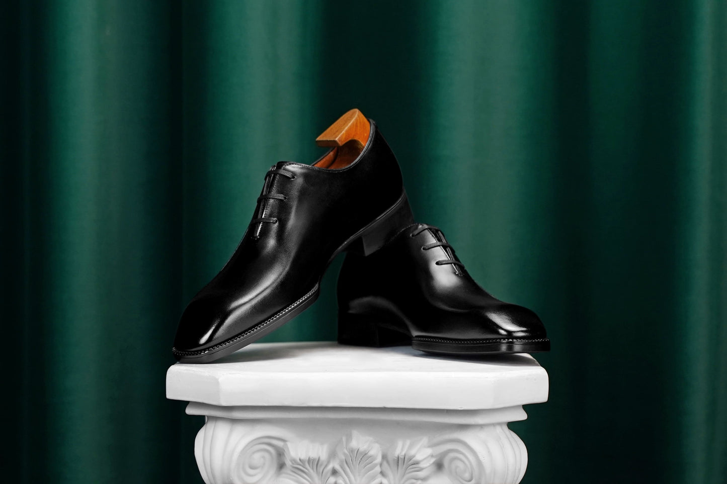 Men’s black leather Oxford dress shoes featuring a polished finish, lace-up closure, sleek pointed toe, and subtle embossed script detailing on the side panel.