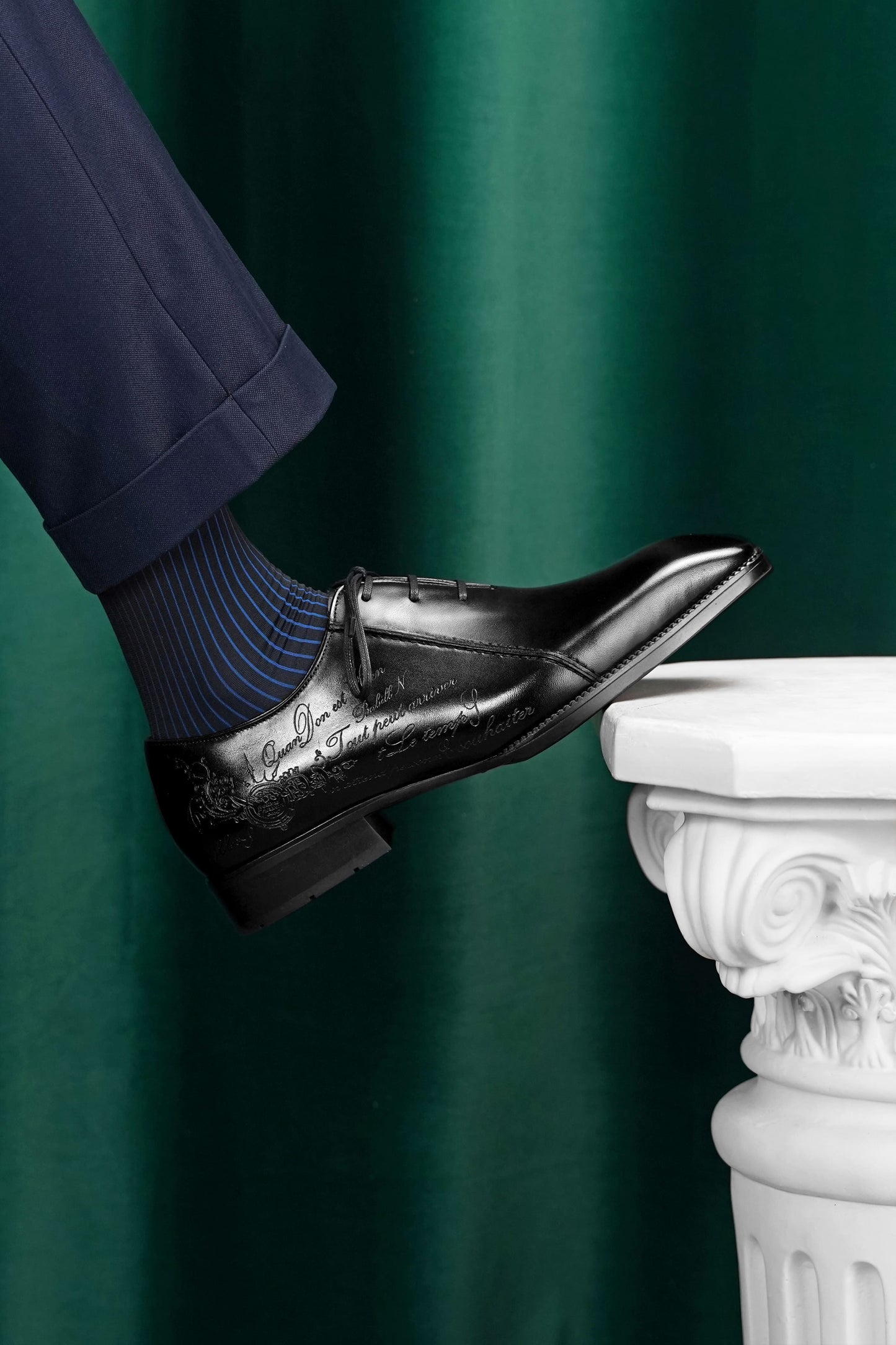 Men’s black leather Oxford dress shoes featuring a polished finish, lace-up closure, sleek pointed toe, and subtle embossed script detailing on the side panel.